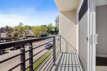 A balcony with a black railing and a white door.
